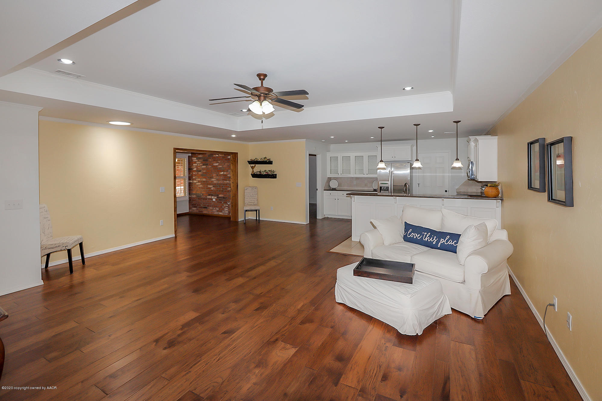 7003 Nick Street Amarillo, TX 79119 - Photo 5 of 34 a large white kitchen with wooden floors and stainless steel appliances