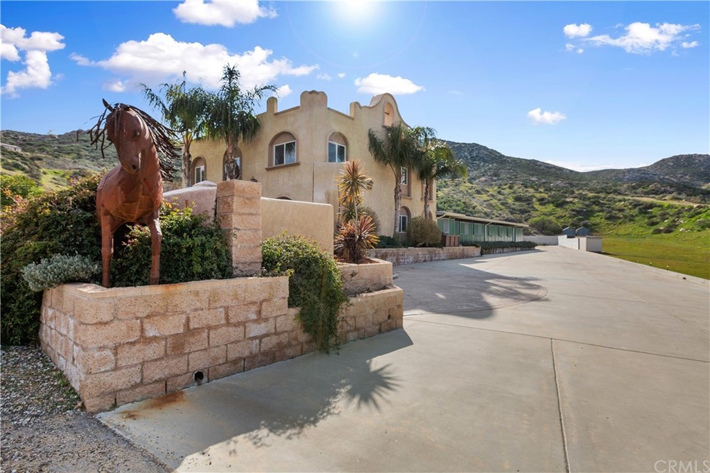 15303 Del Rita Road Banning, CA 92220 - Photo 1 of 1 a view of a white house with a big yard and potted plants