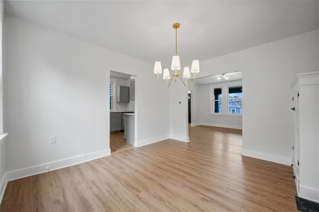 a view of a livingroom with a chandelier fan and wooden floor