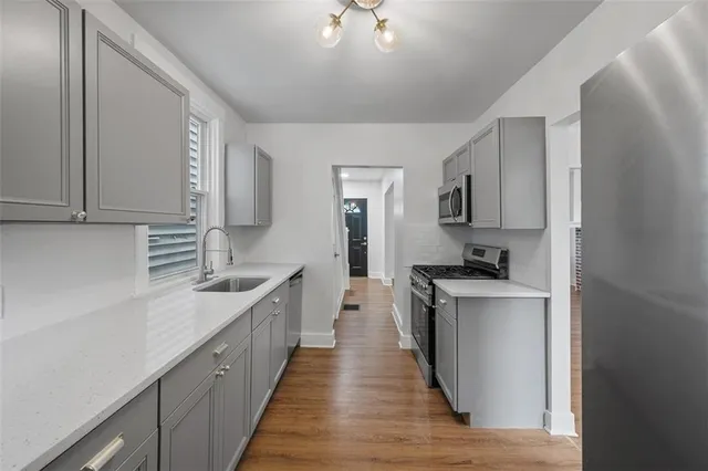 a kitchen with stainless steel appliances a sink stove and cabinets