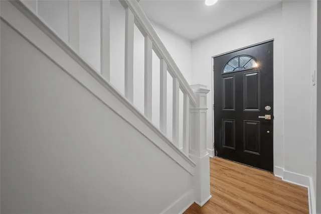 a view of a hallway with wooden floor and staircase