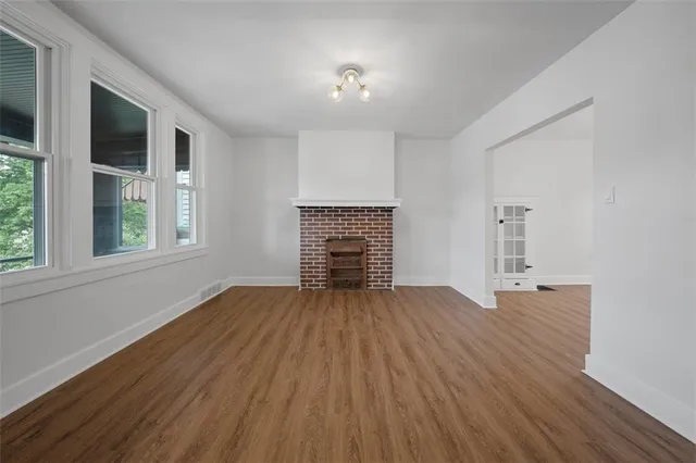 an empty room with windows and fireplace