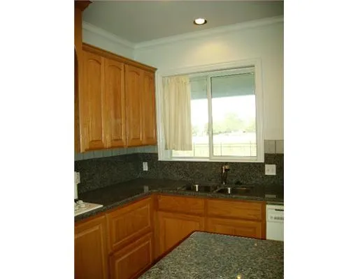 a kitchen with granite countertop white cabinets and sink