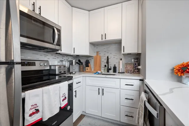 a kitchen with stainless steel appliances granite countertop a sink a stove and cabinets