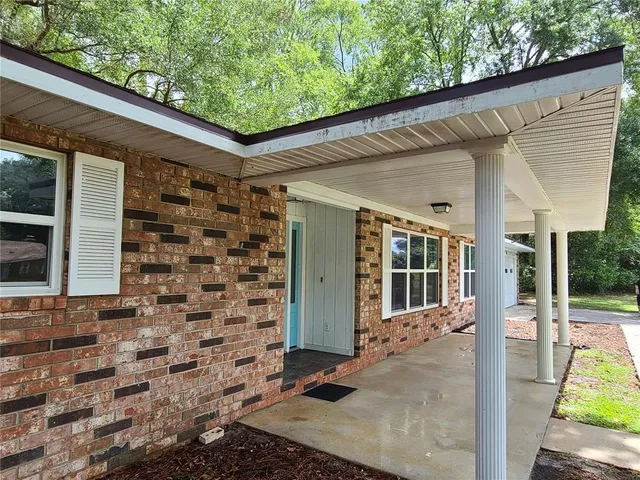 a view of a backyard with table and chairs and floor to ceiling window