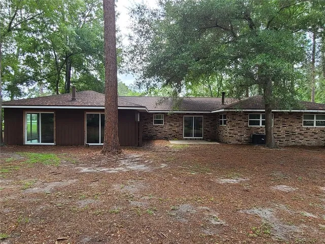 a view of a house with a backyard and tree