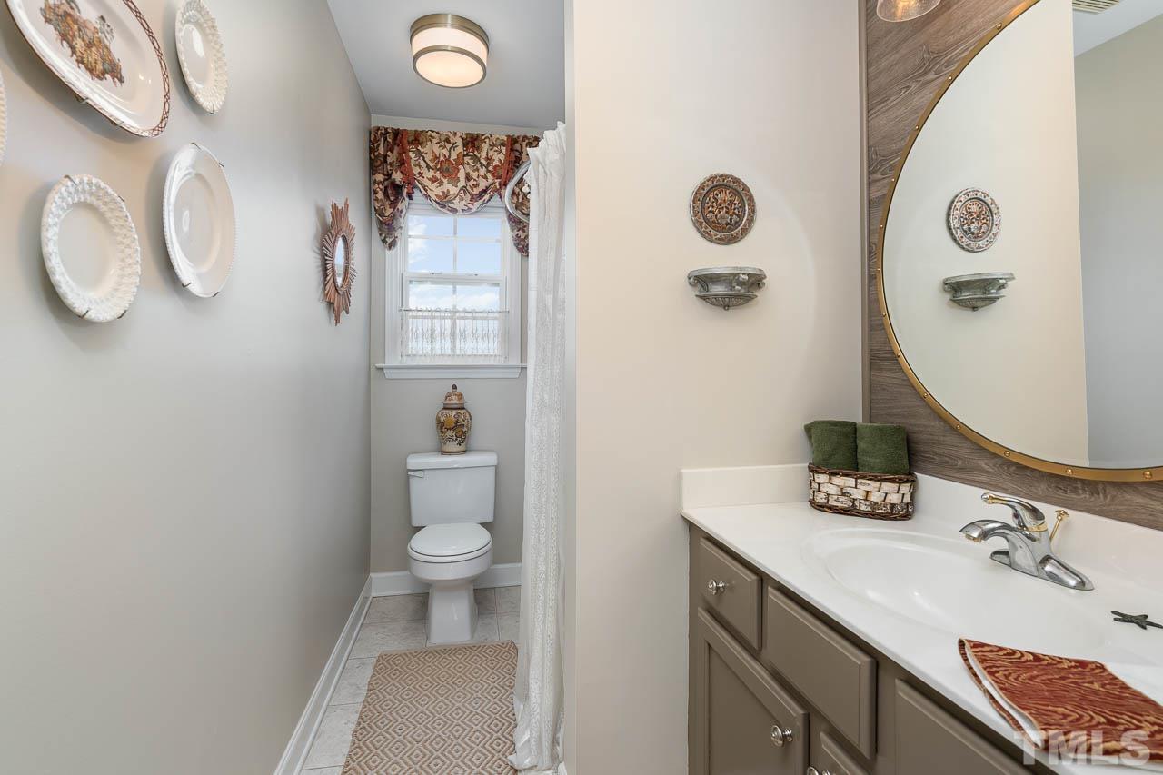612 Seastone Street Raleigh, NC 27603 - Photo 26 of 41 a bathroom with a toilet a sink and mirror