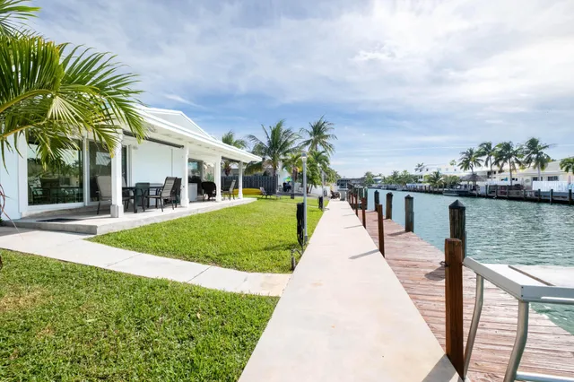 a view of a house with a yard and potted plants