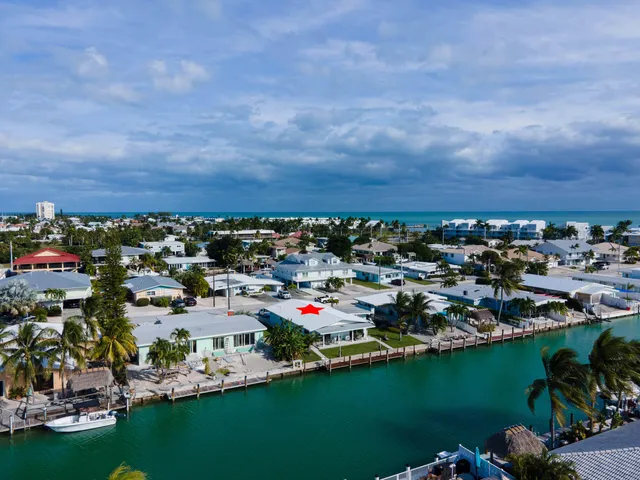 an aerial view of a city with lots of residential buildings ocean and mountain view in back