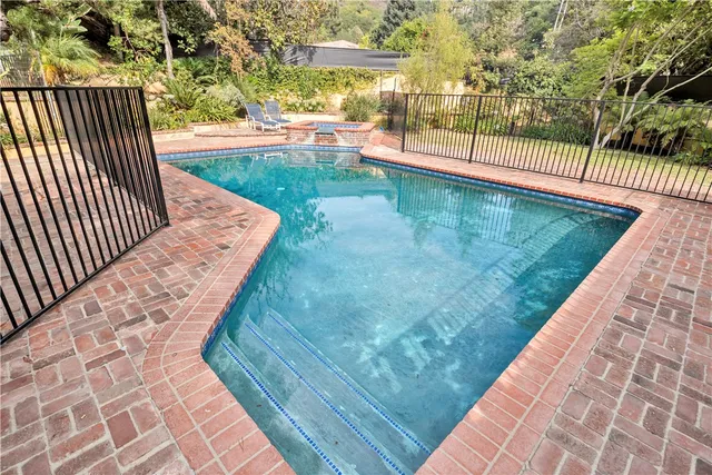 a living room with large windows and plants