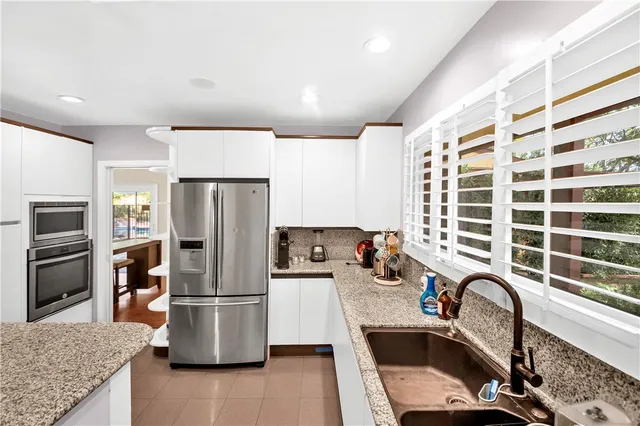 a kitchen with a refrigerator a sink a stove and cabinets