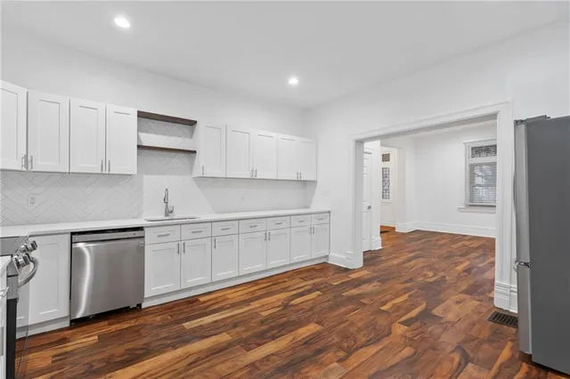 a kitchen with stainless steel appliances granite countertop a stove a sink and a refrigerator