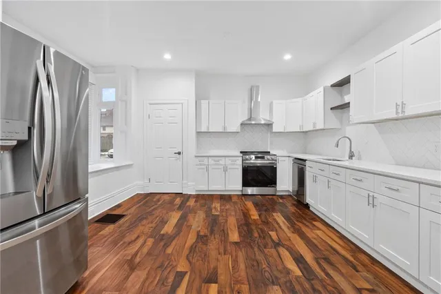 a kitchen with wooden floors and stainless steel appliances