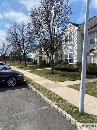 a view of a street with cars parked on the side of road