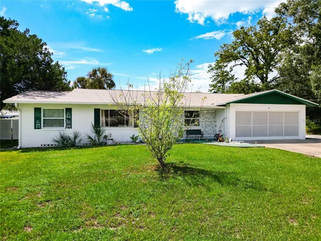 a front view of a house with a garden and yard