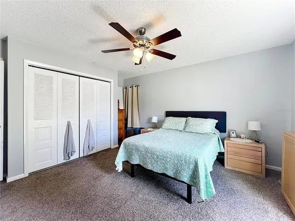 a bedroom with a bed and a ceiling fan