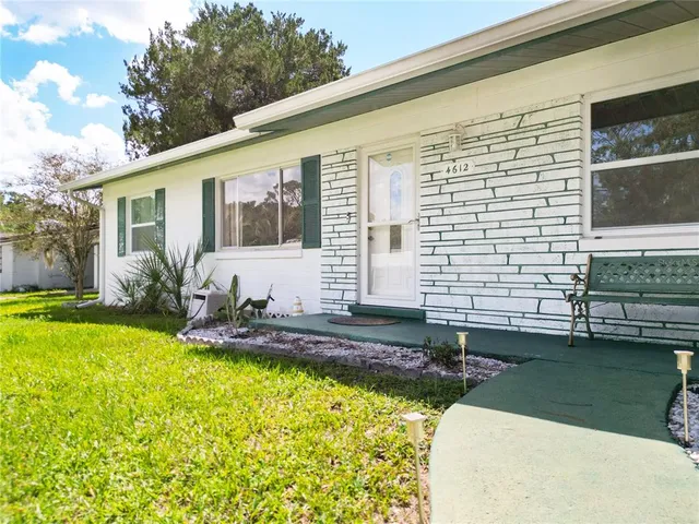 a view of a house with swimming pool and a yard