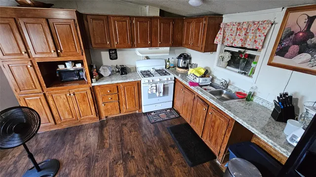 a kitchen with stainless steel appliances granite countertop a refrigerator a stove top oven a sink and dishwasher