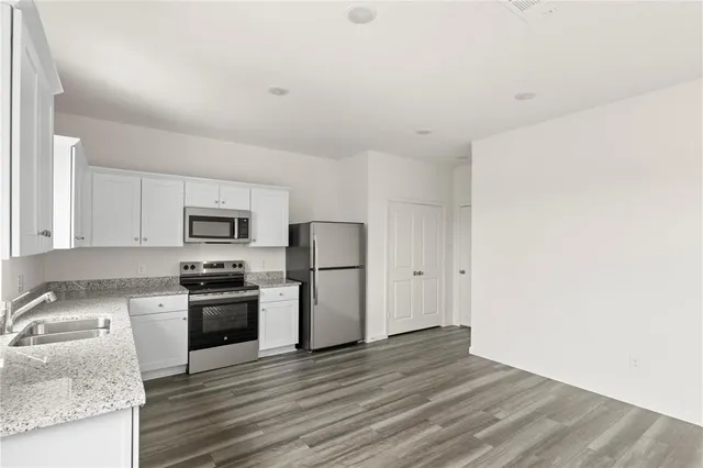 a kitchen with stainless steel appliances granite countertop a stove a refrigerator and a sink