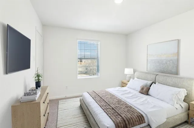 a bedroom with a bed and a flat screen tv