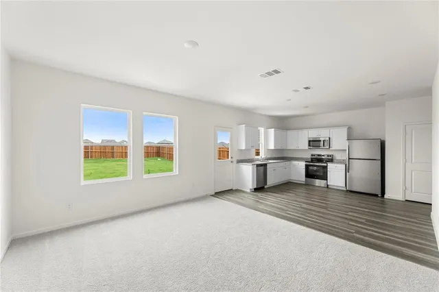 a view of a kitchen with stove and white cabinets