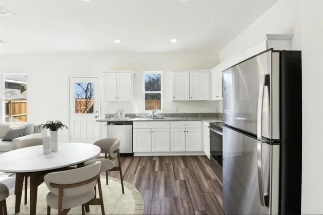 a kitchen with a refrigerator a sink and white cabinets