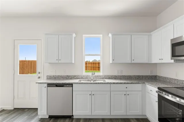 a kitchen with granite countertop white cabinets and white appliances