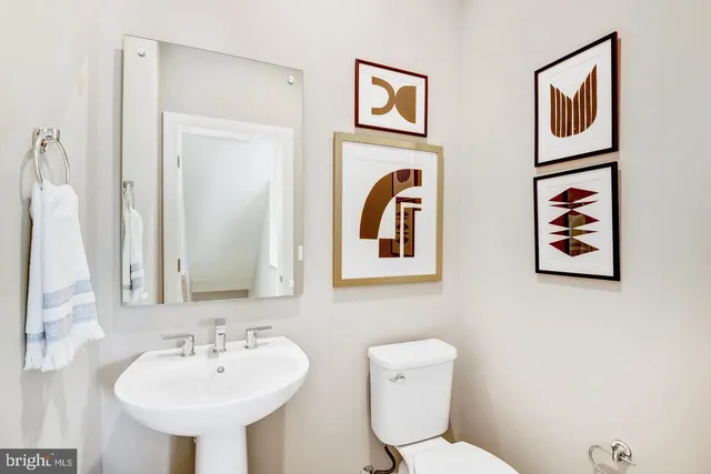 a bathroom with a toilet sink and mirror