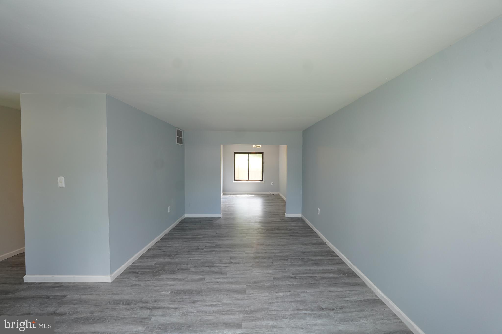 8997 Centerway Road Gaithersburg, MD 20879 - Photo 13 of 71 a view of an empty room with wooden floor and a window