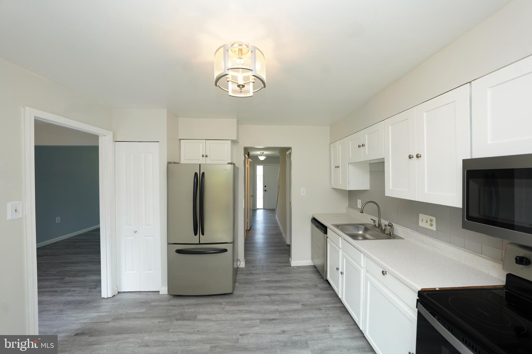 8997 Centerway Road Gaithersburg, MD 20879 - Photo 16 of 71 a large kitchen with a refrigerator and a sink