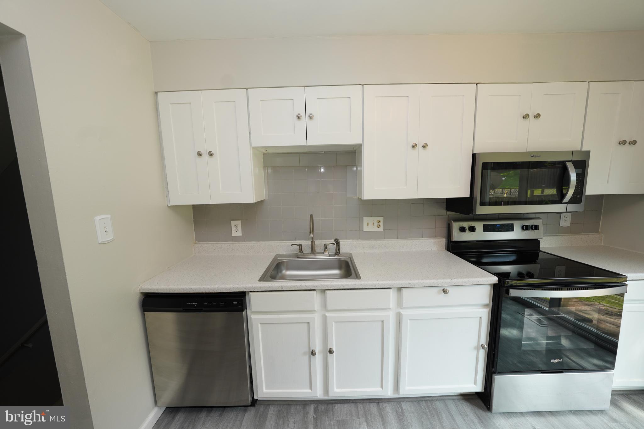 8997 Centerway Road Gaithersburg, MD 20879 - Photo 17 of 71 a kitchen with white cabinets and stainless steel appliances
