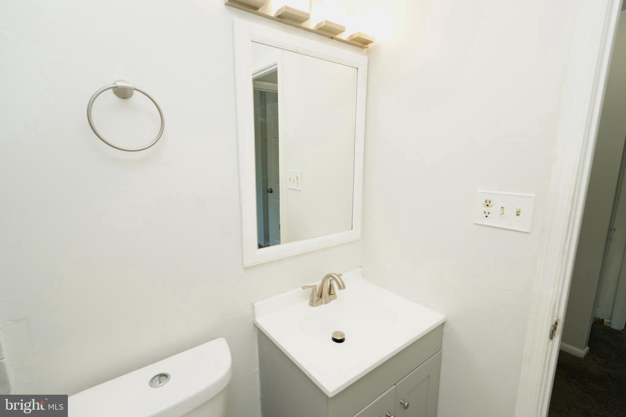 8997 Centerway Road Gaithersburg, MD 20879 - Photo 31 of 71 a bathroom with a sink a toilet and mirror