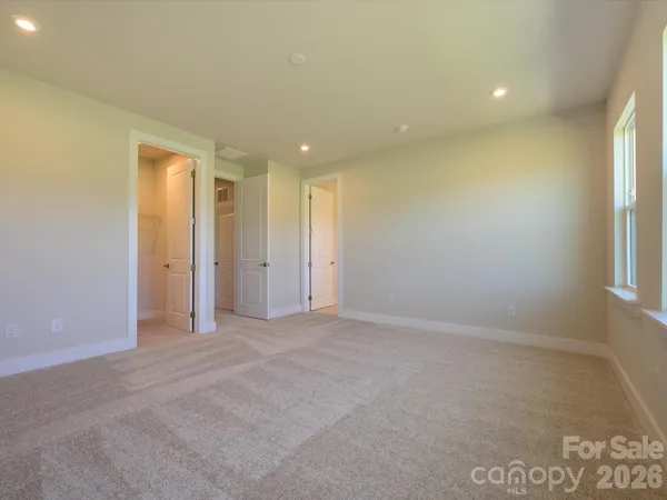 an empty room with windows and closet