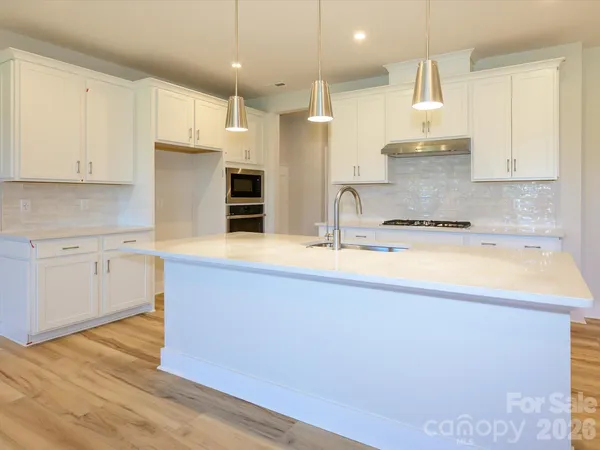 a kitchen with kitchen island a sink stainless steel appliances and cabinets