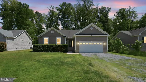 a front view of a house with yard and green space