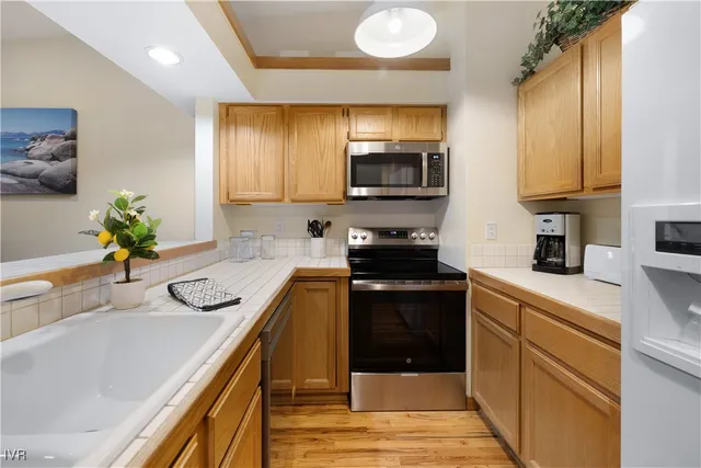 a kitchen with stainless steel appliances a sink a stove top oven a counter space and cabinets