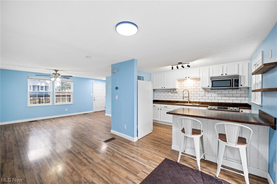 4251 Kenneth Road Stow, OH 44224 - Photo 5 of 19 Kitchen with light hardwood / wood-style flooring, ceiling fan, track lighting, white fridge, and white cabinetry