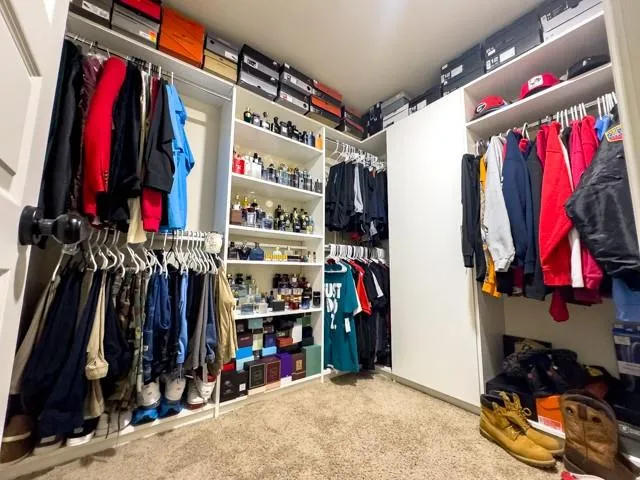 a view of walk in closet with clothes