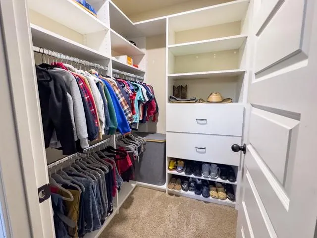 a view of walk in closet with clothes and shoes