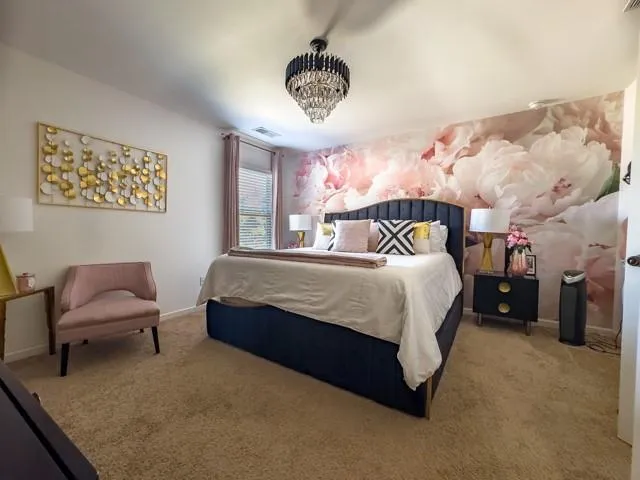 a spacious bedroom with a bed and a chandelier