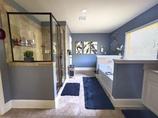 a living room with stainless steel appliances furniture a rug and a window