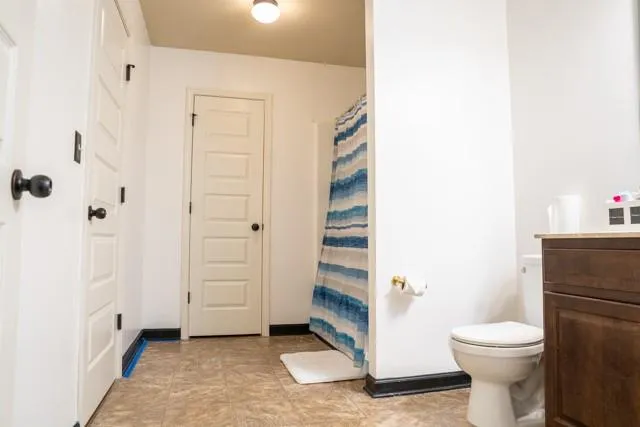 a bathroom with a toilet and a shower
