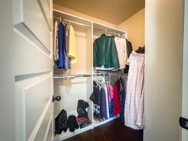 a view of walk in closet with clothes and shoes