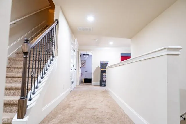 a view of a hallway with wooden floor and staircase