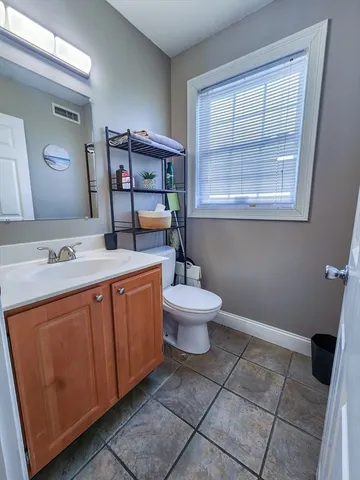 a spacious bathroom with a toilet sink and mirror