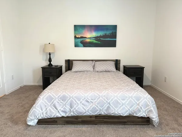 a bedroom with a bed and a painting on the wall