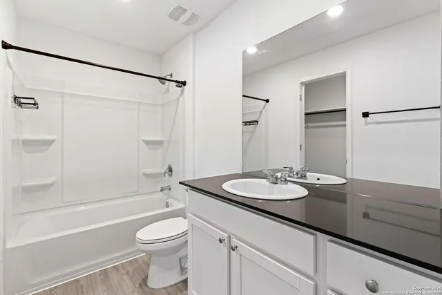 a bathroom with a granite countertop sink toilet and shower