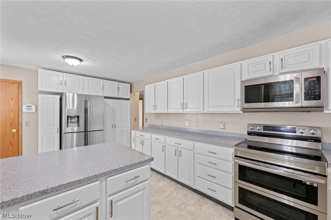 5100 McCormick Road Ravenna, OH 44266 - Photo 7 of 34 Bright kitchen with corian counter tops and new stove and refrigerator