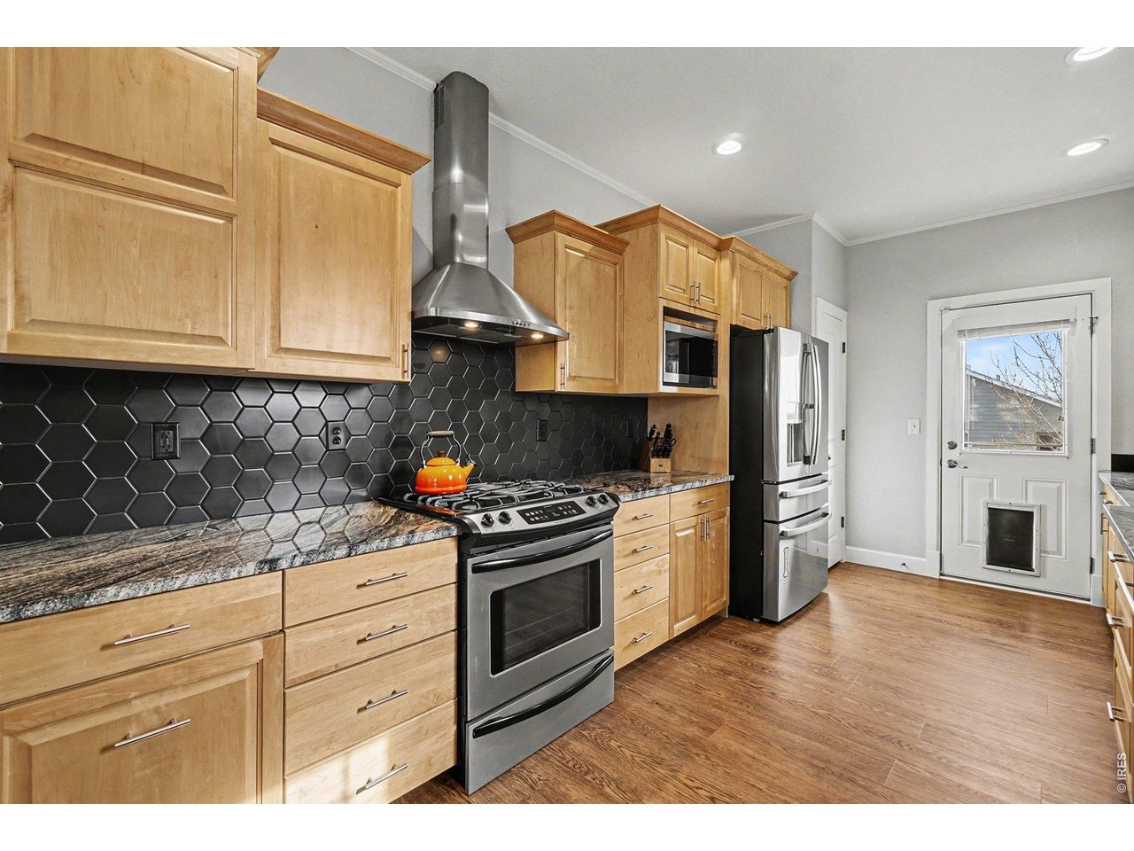 844 Cliffrose Way Severance, CO 80550 - Photo 11 of 50 a kitchen with stainless steel appliances granite countertop a stove a sink and a refrigerator