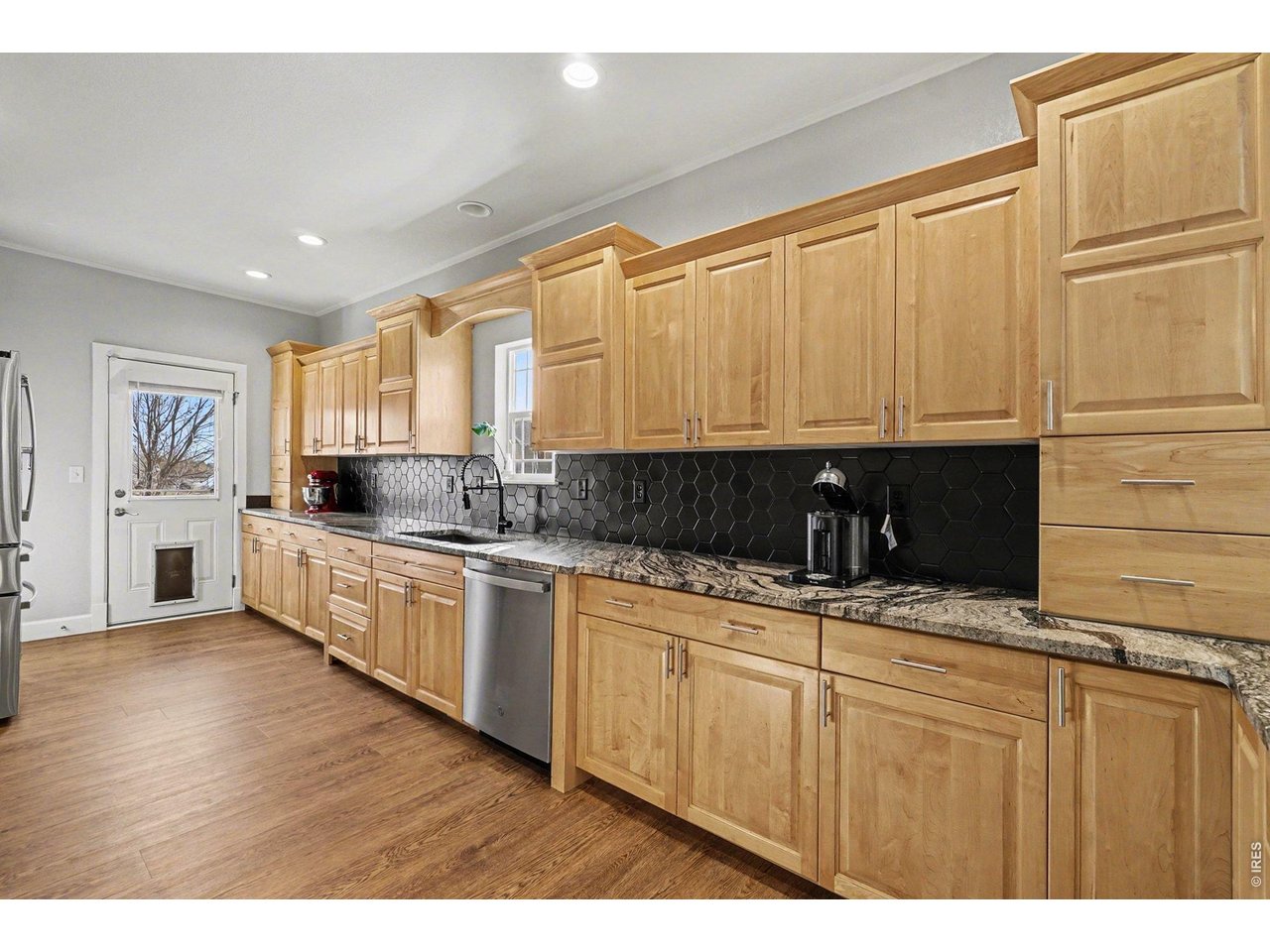 844 Cliffrose Way Severance, CO 80550 - Photo 13 of 50 a kitchen with granite countertop a sink stainless steel appliances and cabinets